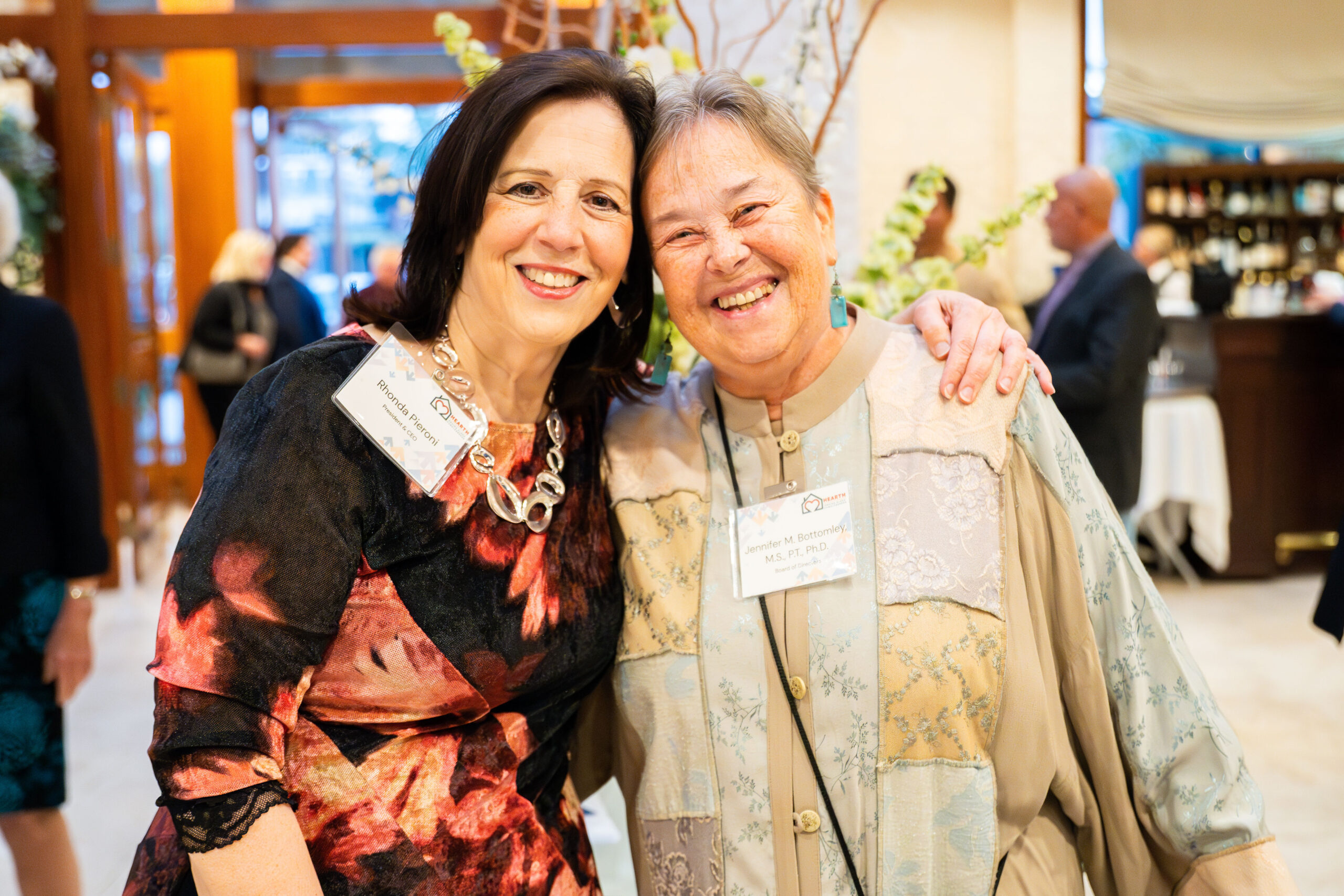 Two Hearth Home volunteers smiling and looking at the camera at an volunteer event for ending older adult homelessness in Boston.